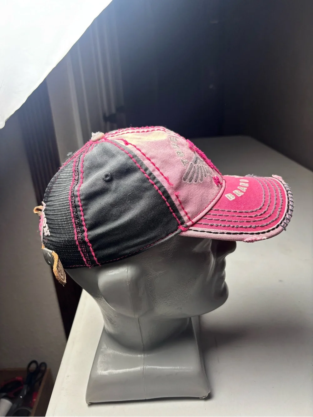 pink, distressed True Religion brand jeans cap with embroidered wings and a logo
